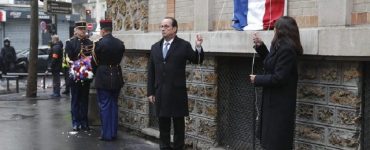 French President Francois Hollande and Paris Mayor Anne Hidalgo unveil a commemorative plaque next to the "La Belle Equipe" bar and restaurant in Paris, France, Sunday, Nov. 13, 2016, during a ceremony held for the victims of last year's Paris attacks which targeted the Bataclan concert hall as well as a series of bars and killed 130 people. (Philippe Wojazer/Pool Photo via AP)